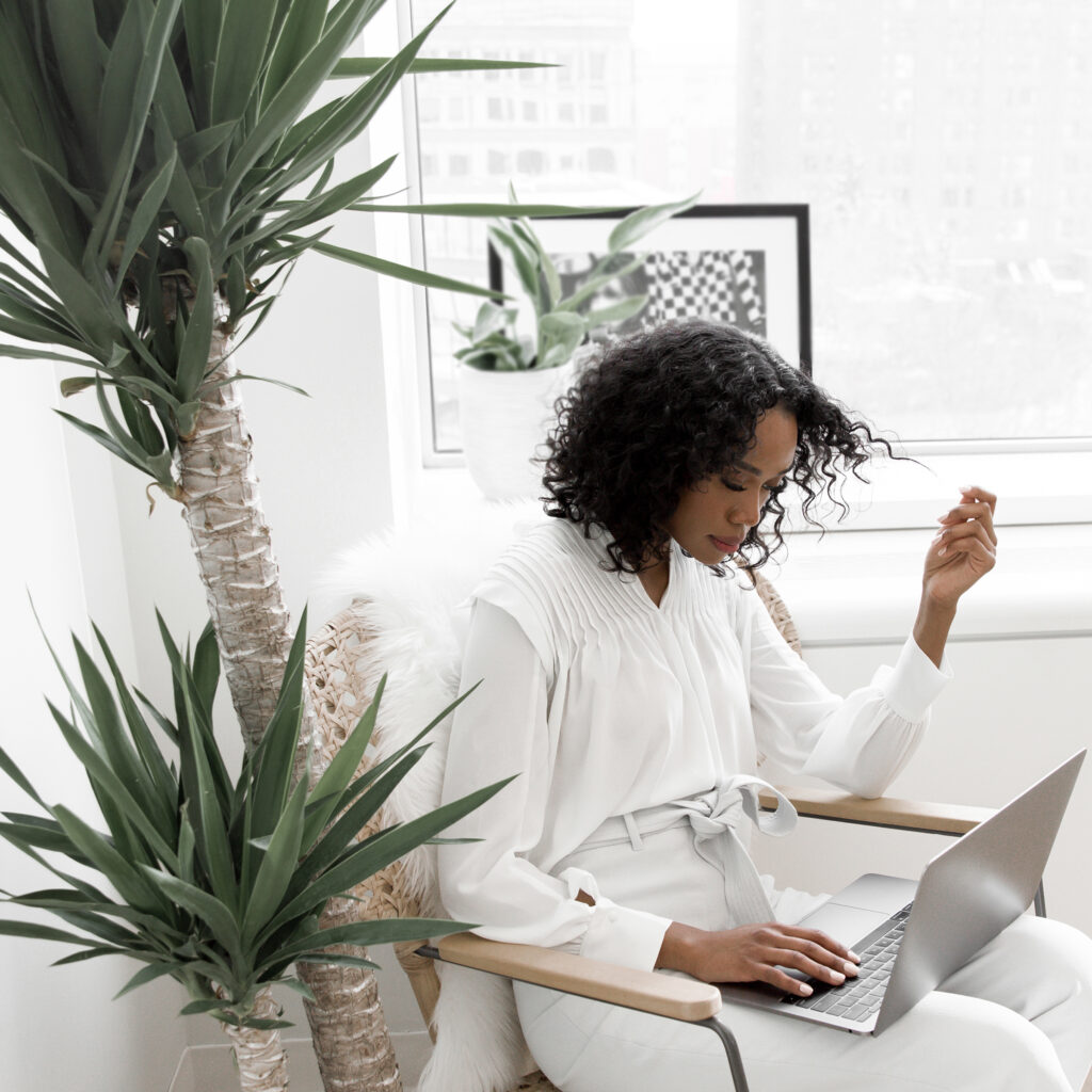 Frau mit Laptop und Pflanze