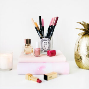 Glas mit verschiedenen rosa Brushpens neben rosa Accessoires